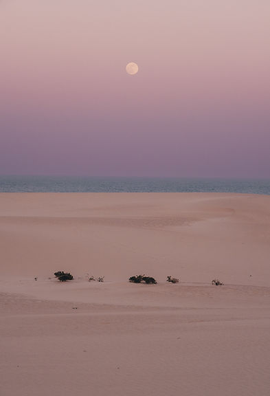full moon rising over the desert and ocean in furteventura, spain