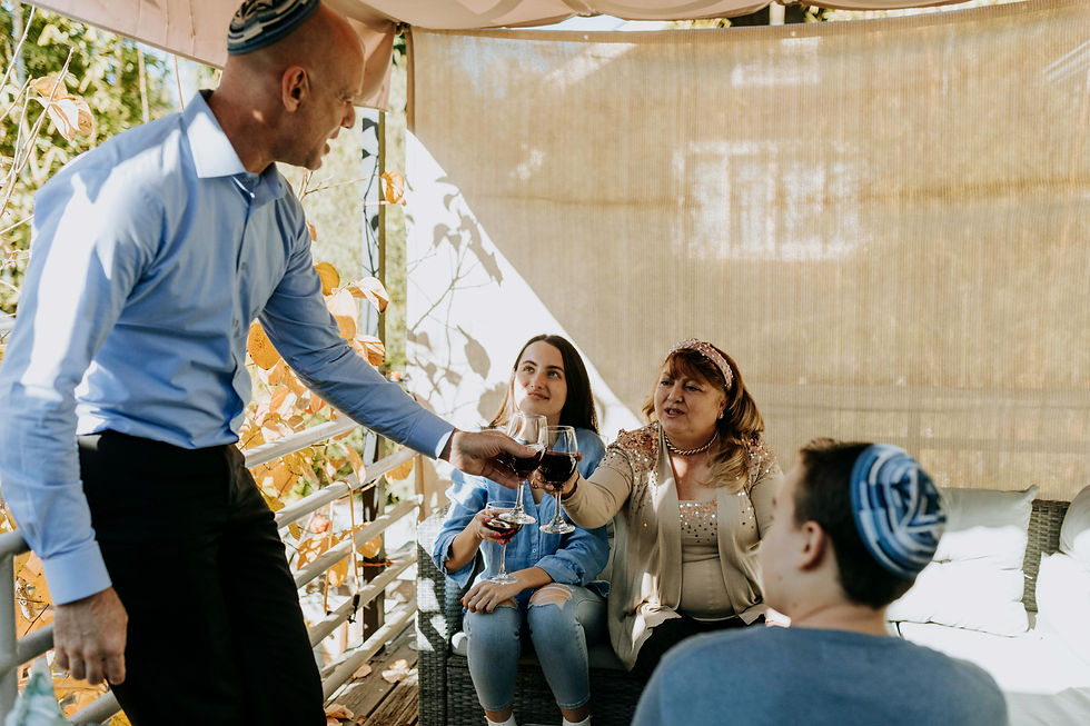 Jewish family sitting in a sukkah, raising glasses of wine in celebration of Sukkot.