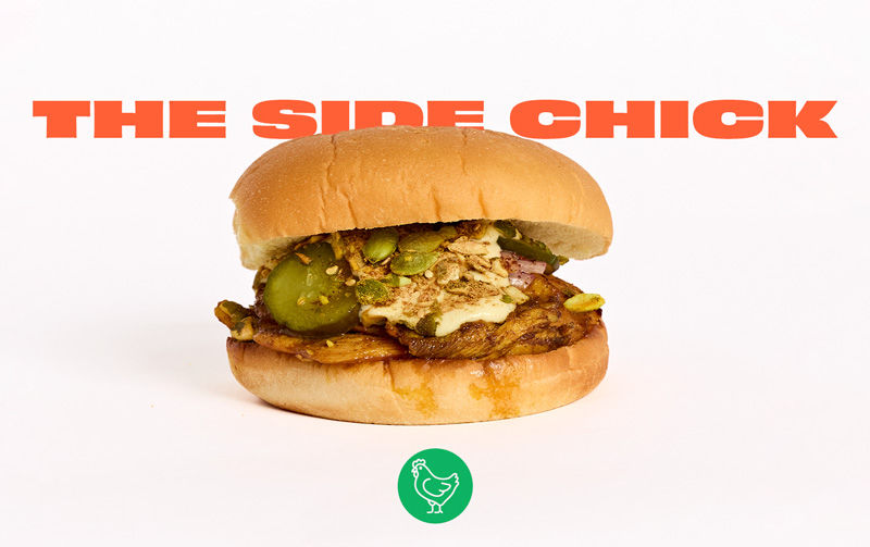 Burger with chicken, pickles, and sauce on a bun against a white background. Text: "The Side Chick" in bold orange above a green chicken icon.