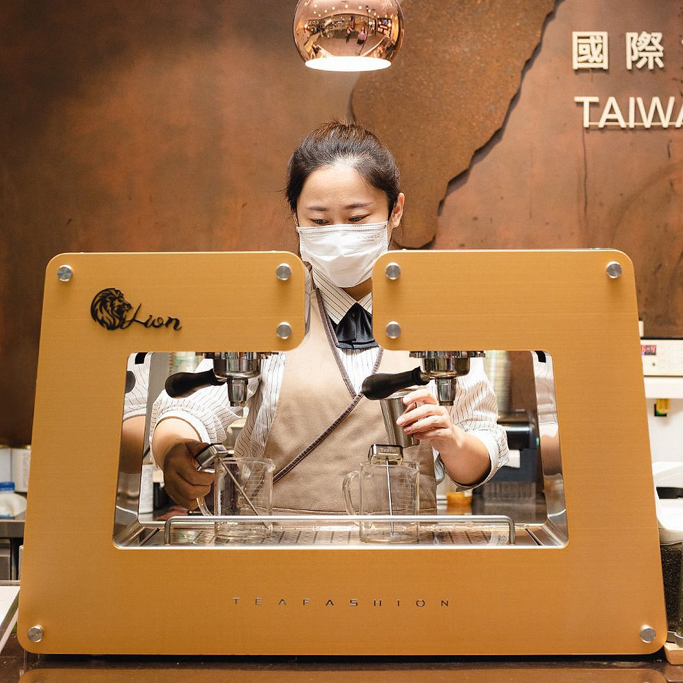 Barista in mask operates a beige espresso machine named "Lion" in a café. Background features warm tones and text "TAIWAN."
