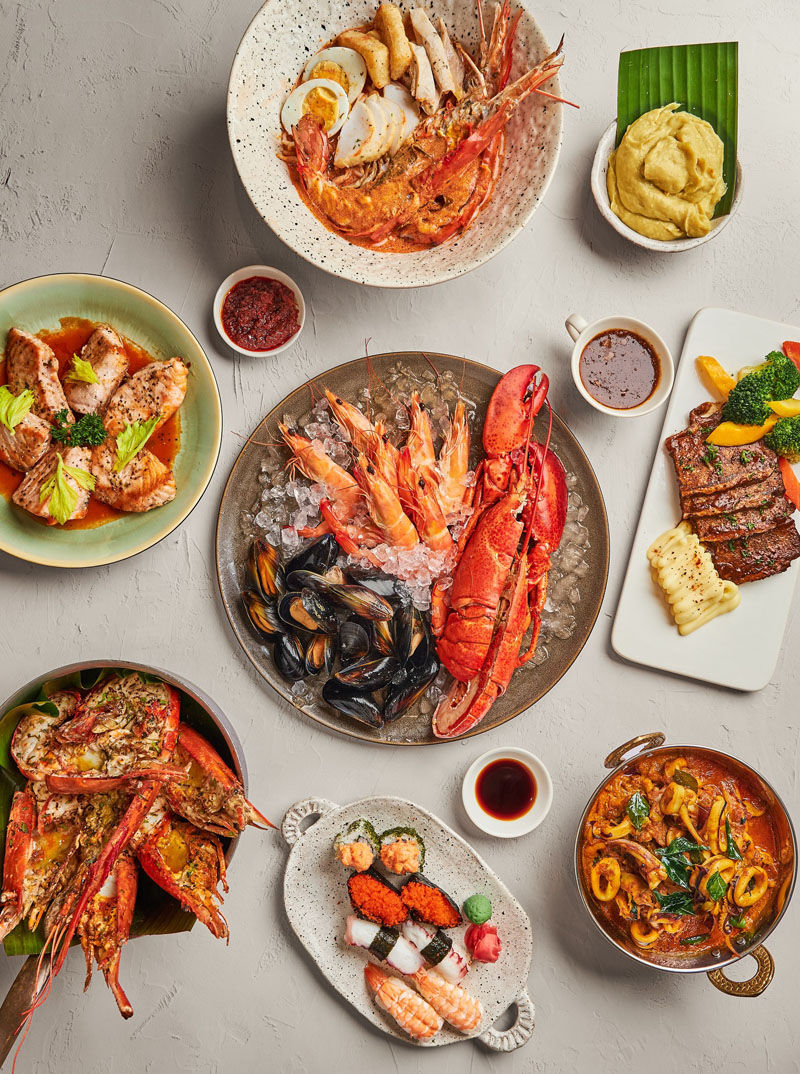 Assorted seafood dishes on a table, including shrimp, lobster, sushi, and grilled fish. Accompanied by sauces, creating a vibrant feast.