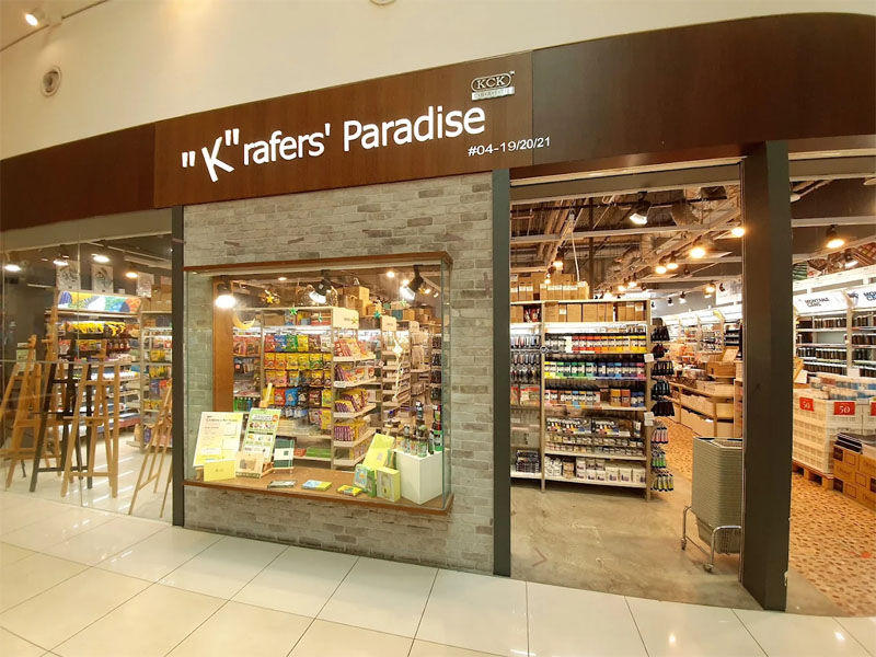 Storefront for "Krafer's Paradise," showcasing a craft supply shop with bright lights, organized shelves, and a welcoming display.