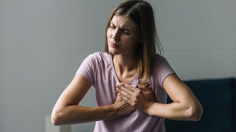 woman clutching chest in discomfort
