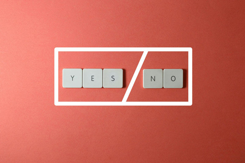 Keyboard keys spelling YES and NO on a red background, divided by a white line, creating a decision theme.
