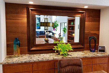 A mirror reflecting the dining room and family room