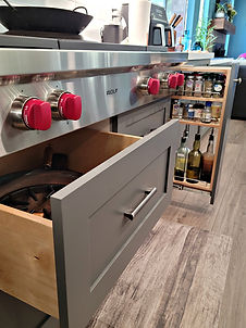Deep drawers and slide out spice organizer in this transitional kitchen and a wolf range