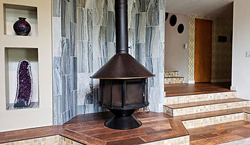 Contemporary tile fireplace surround resembles a waterfall and tumbled marble toe-kicks make sure people are safe