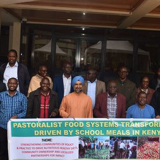 Members of the Kenya Community of Policy & Practice gathered for a photograph with a sign