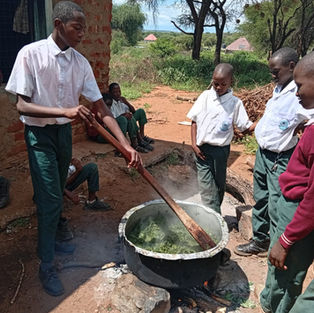 School children stirring a pot of vegetables