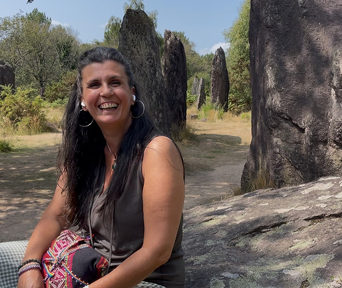 Chamane souriant parmis les menhirs