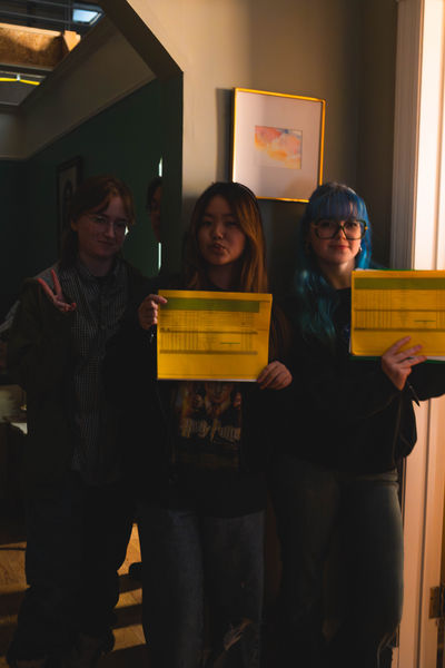 Figure Frenzy Production designer, 1st and 2nd Assistant Directors smiling and holding up paperwork Photographed by Mahin Karani (Simone Kessler, Michelle Nugroho, Jenna Monckton)