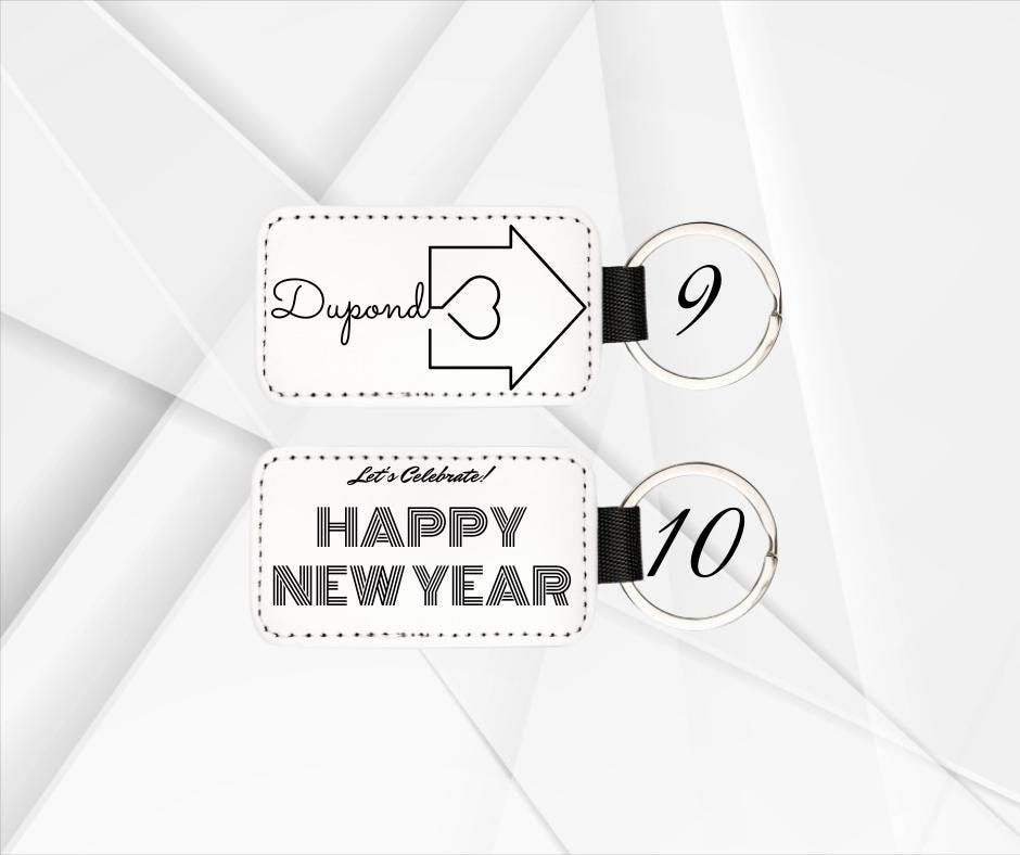 Miniature : Peut inclure: Deux porte-clés blancs avec du texte noir et une sangle noire. Le premier porte-clés dit "Dupond" avec un cœur et une flèche. Le deuxième porte-clés dit "Let's Celebrate! Happy New Year".