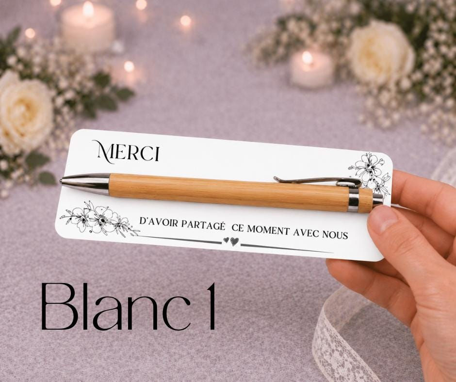 Miniature : Peut inclure: Un stylo à bille en bambou avec des détails en métal argenté fixé sur une carte rectangulaire blanche. La carte présente des illustrations florales noires et le texte MERCI D'AVOIR PARTAGÉ CE MOMENT AVEC NOUS avec deux petits cœurs.