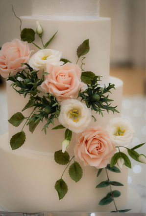 A wedding cake with hand made sugar thistles, lisianthus and blush pink roses with leaves