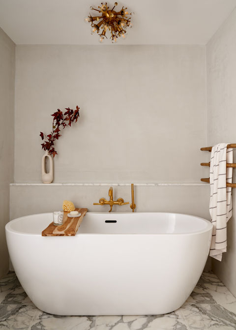 Contemporary bathroom design with white tub and gold accents.