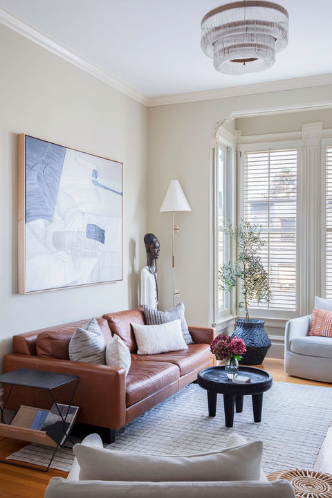 Timeless neutral living room design with rust colored sofa and accent pillows.