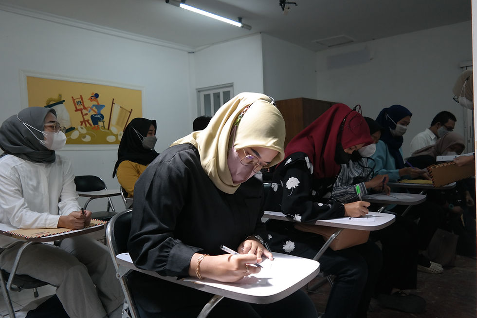 Di ruangan yang luas, seorang perempuan mengenakan hijab berwarna kuning terlihat fokus mengerjakan ujian.