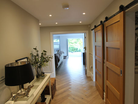 Contemporary living space with pocket doors within the wall, creating flexible open-plan flow.