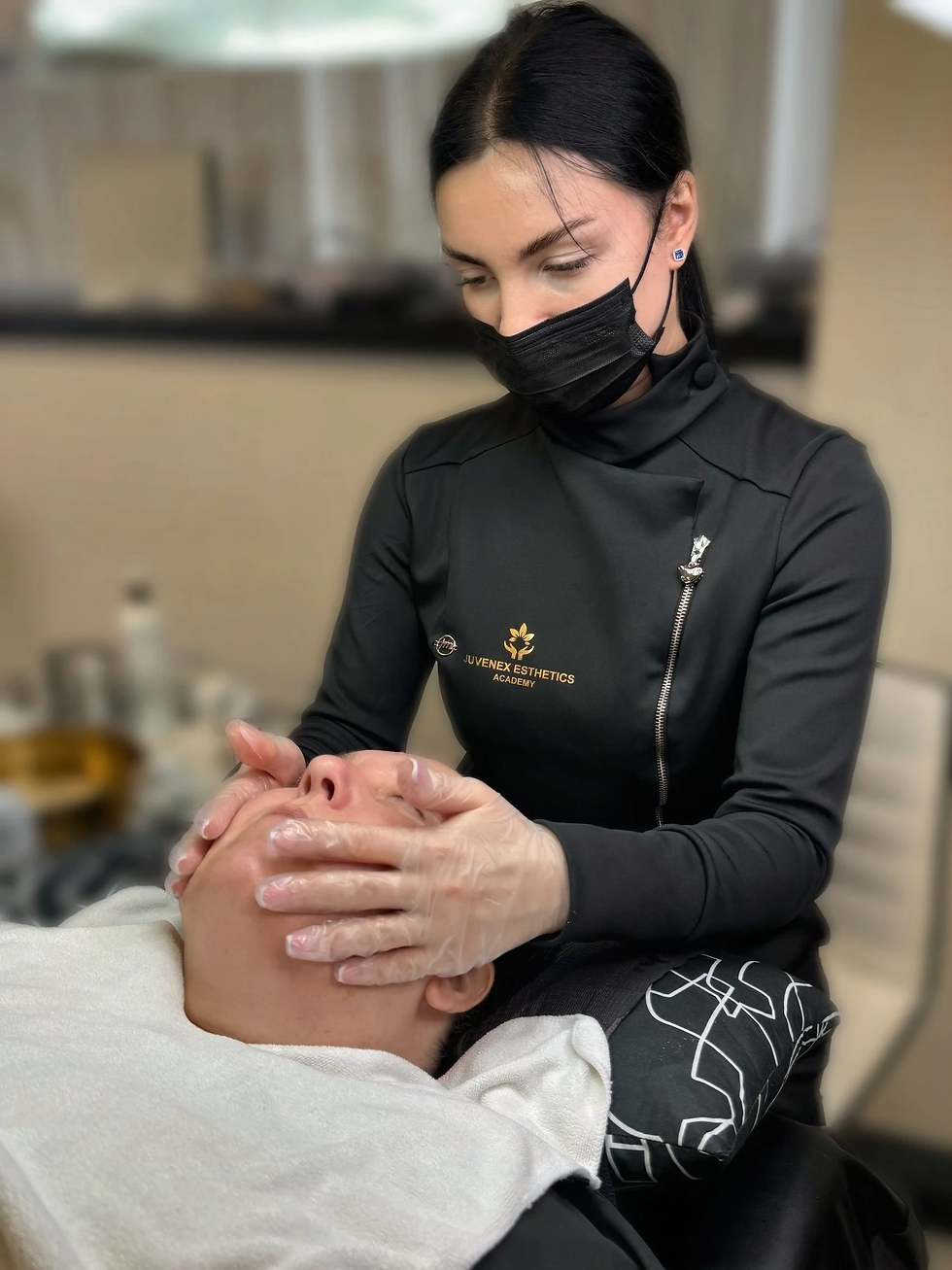 Juvenex Facial massage in progress — student performing massage techniques under instructor supervision.