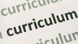 Paper with the word curriculum typed on it three times.