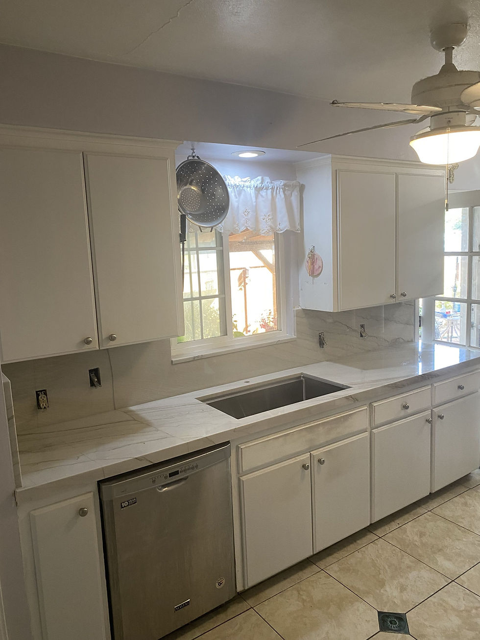Modern kitchen with granite countertop installation and white cabinets
