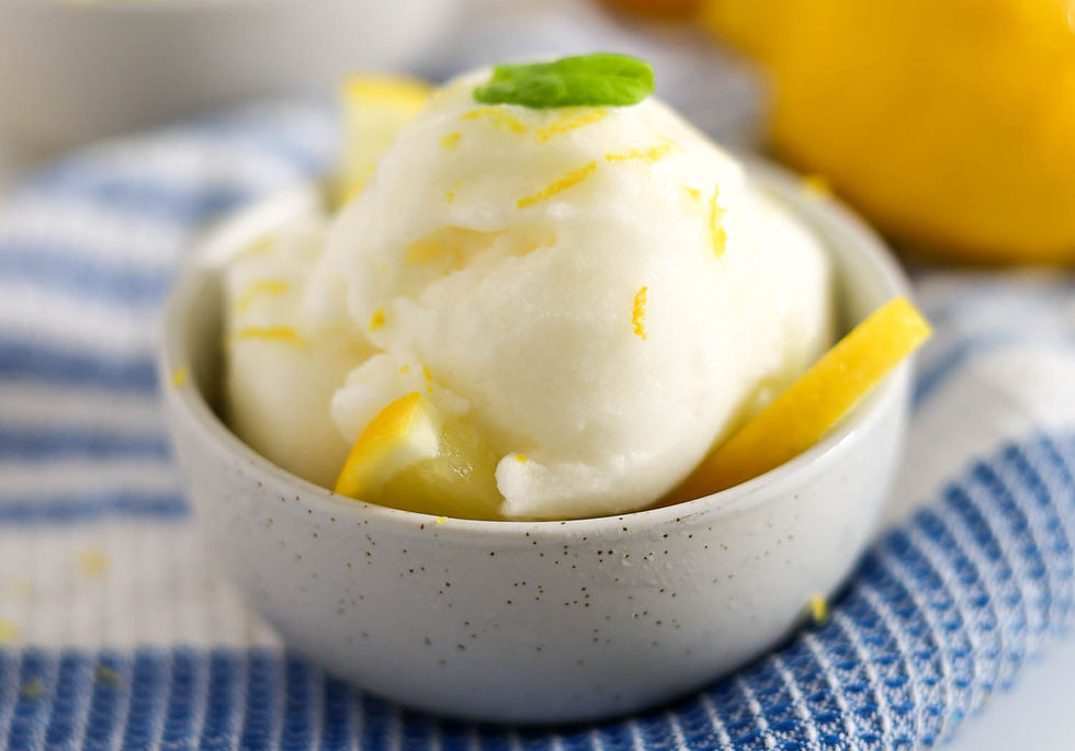 Bowl of soft serve ice ceam garnished with lemon zest and basil on a blue-striped cloth. Bright, refreshing, and inviting scene.