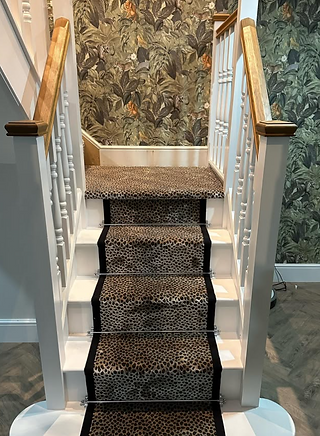 A leopard print stair runner with black cotton tape on the edges