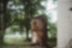 Old metal water tank next to an 1898 farmhouse, surrounded by trees, showing original utilities on the property during early restoration