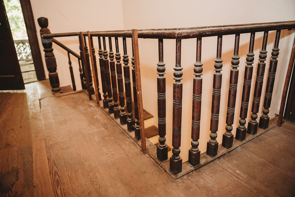 Second-story stair railing with missing spindles and low height in 1898 Victorian farmhouse hallway