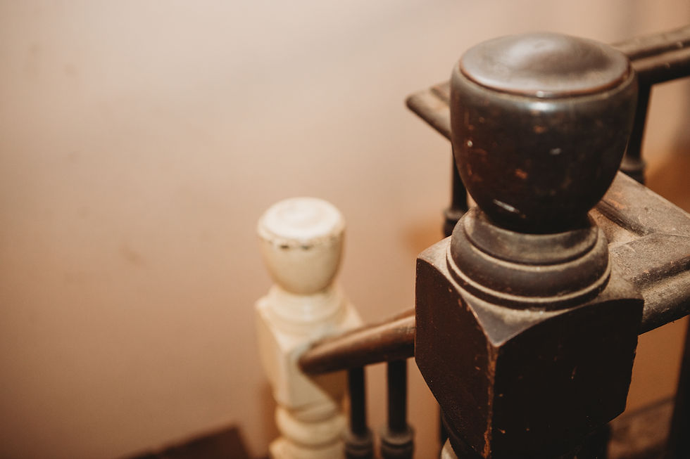 Close-up of stair railing transition from painted to exposed wood in second story Victorian farmhouse