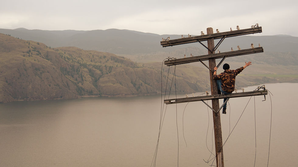 Guy sitting on electricity pylon