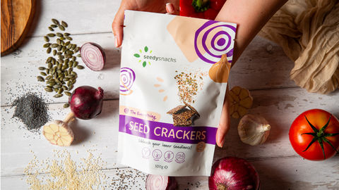 Hands holding Seed Crackers bag; healthy snack