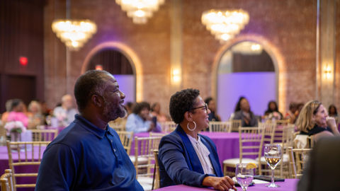 A Lasting Legacy AC4Ed at The Revelry located in Camp North End. Engaging audience and educators sit at the table while listening to speaker.