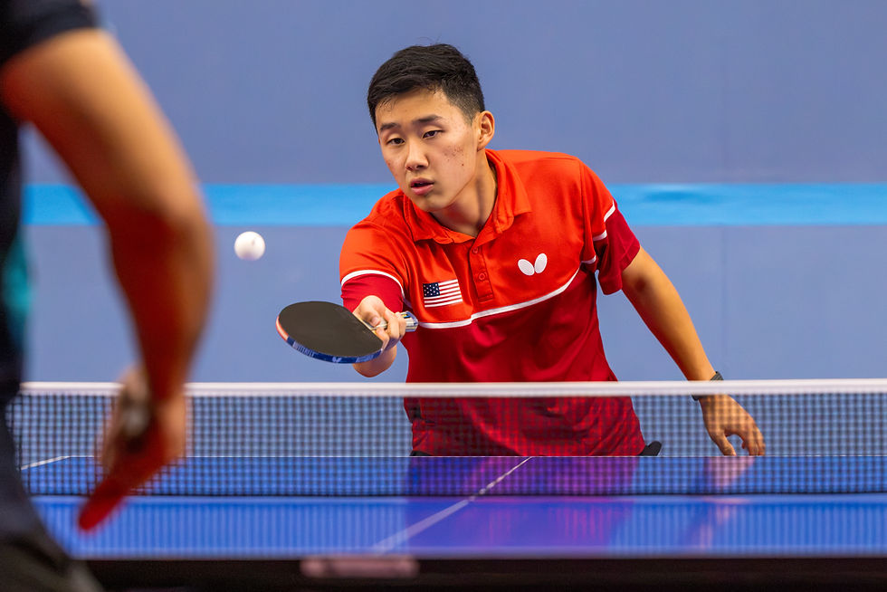 Michael Guo, co-captain of the UT Table Tennis Team, holding a paddle during a table tennis match at Austin Table Tennis Club.