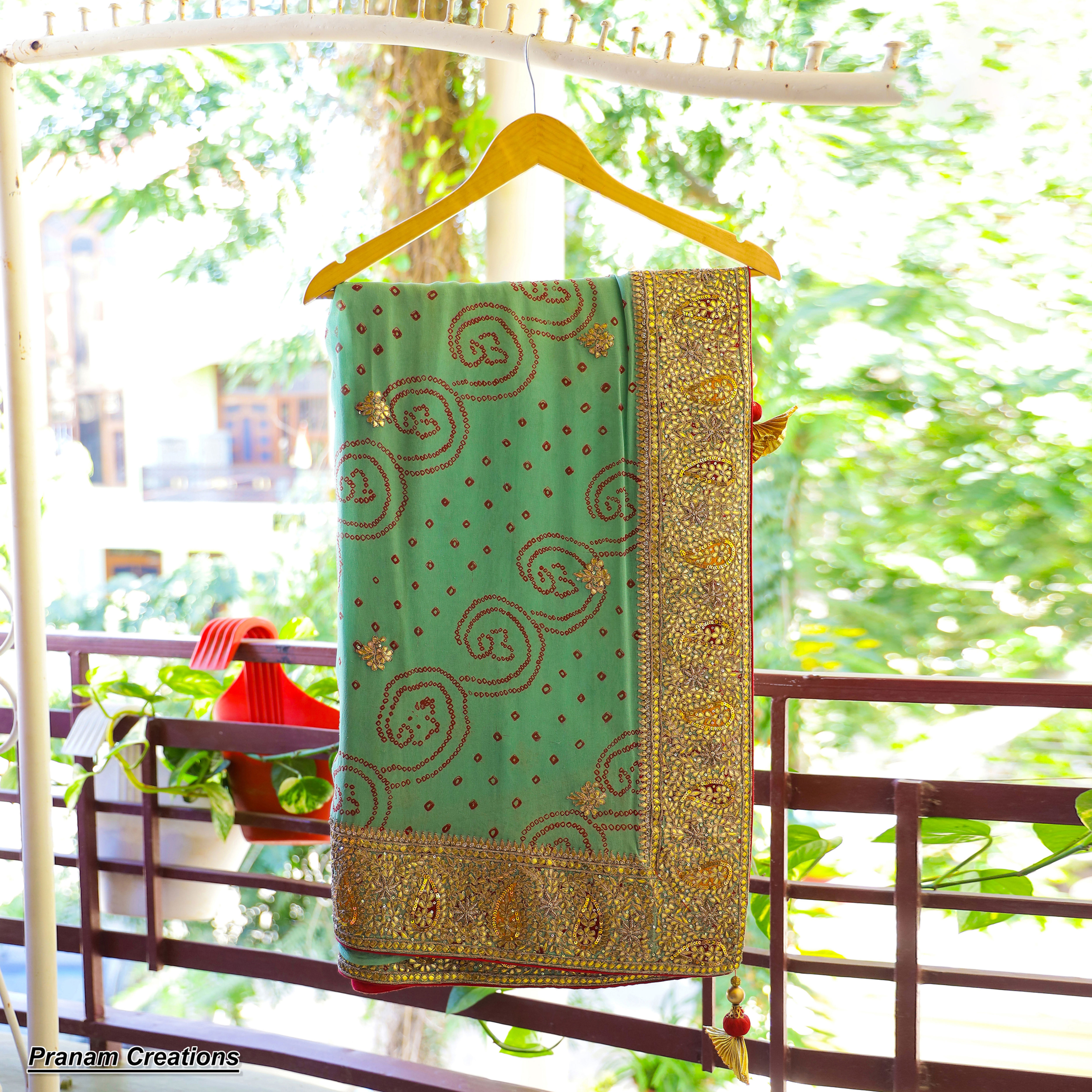 Pista green pure georgette saree with maroon-red bandhej detailing & gotta patti