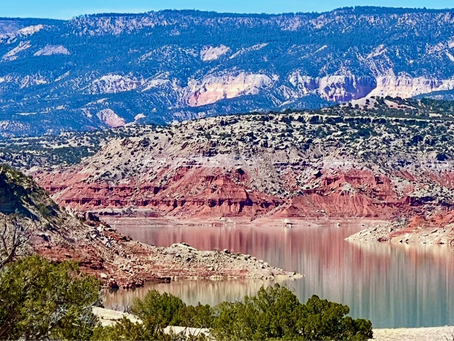 Red cliffs rise above Abiquiu Lake.