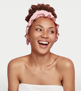 pretty-smiling-woman-looks-right-side-stands-wrapped-towel-with-naked-shoulders-wears-show