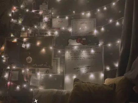 fairy light strung up against a wall covered in random trinkets