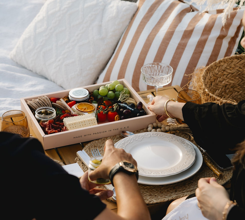Couple enjoying a private winter lakeside picnic by Picnic Times in Dubai, relaxing on plush cushions and sharing gourmet treats in a serene outdoor setting.