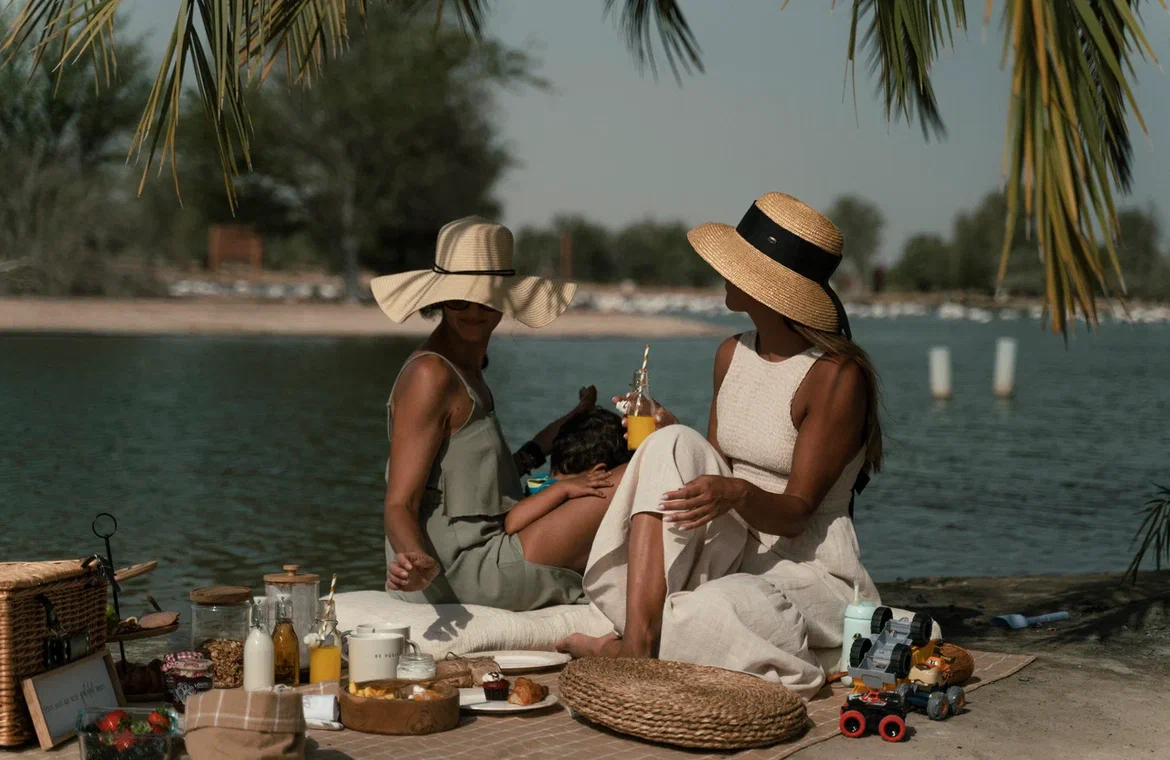 Luxury outdoor picnic by PicnicTimes with basket, juices, and cozy seating, capturing simple joys.