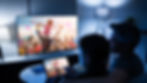 Two adults sitting on a couch watching the TV and viewing their mobile phone