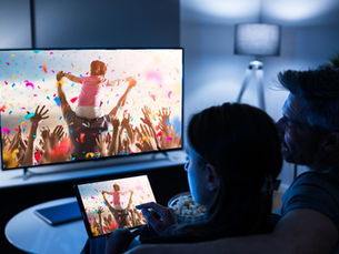 Couple watching TV and laptop