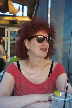 Barbara Romain in sunglasses and a red top, outdoors