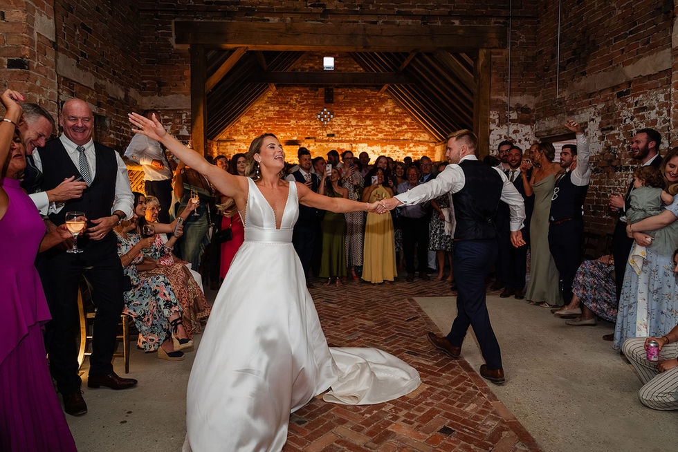 Bride and groom’s first dance at The Mill Hoveringham, surrounded by cheering guests. Natural and joyful wedding photography.