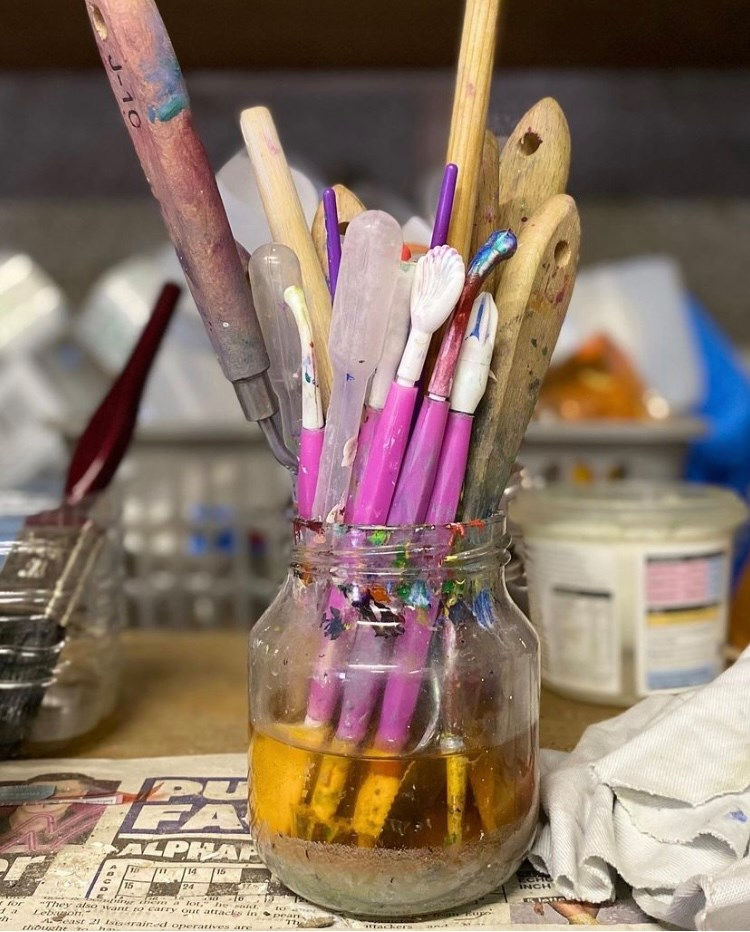 Sensational spring Cleaning - a pot of artist's tools on a cluttered desk
