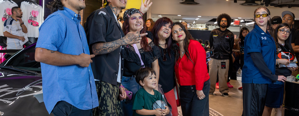 An entire family poses with artist Cuco inside shoe palace in Los Angeles