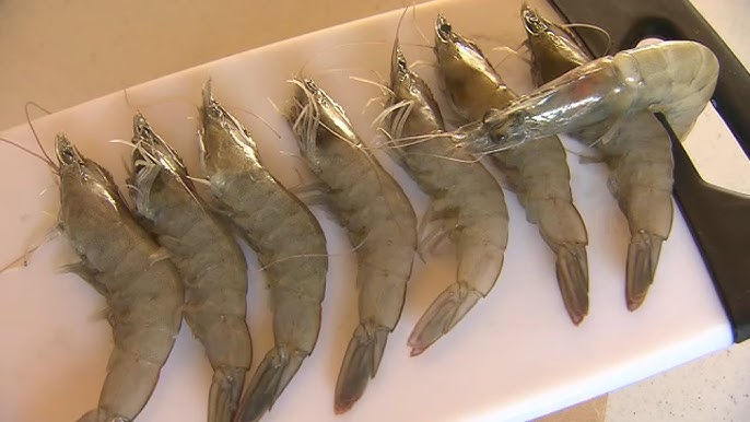 Raw shrimp arranged on a white cutting board, similar to the Great Value shrimp recalled by Walmart due to potential Cesium-137 contamination.