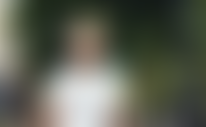 Man wearing white JBL Tune 770NC wireless noise cancelling headphones outdoors, walking confidently in a city setting, demonstrating over-ear Bluetooth headphones for everyday use.