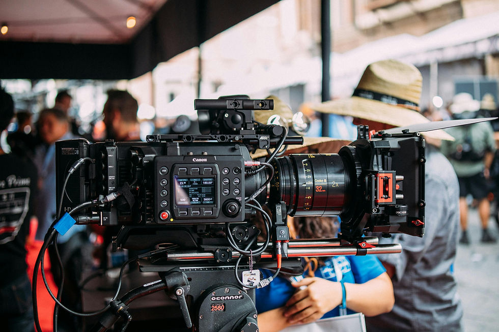 Professional Canon cinema camera setup on a film set in Miami, surrounded by crew members preparing for a video production shoot.