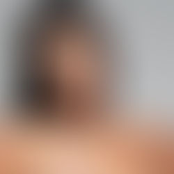 Kim Kardashian posing in nude Skims shapewear against a plain gray background.